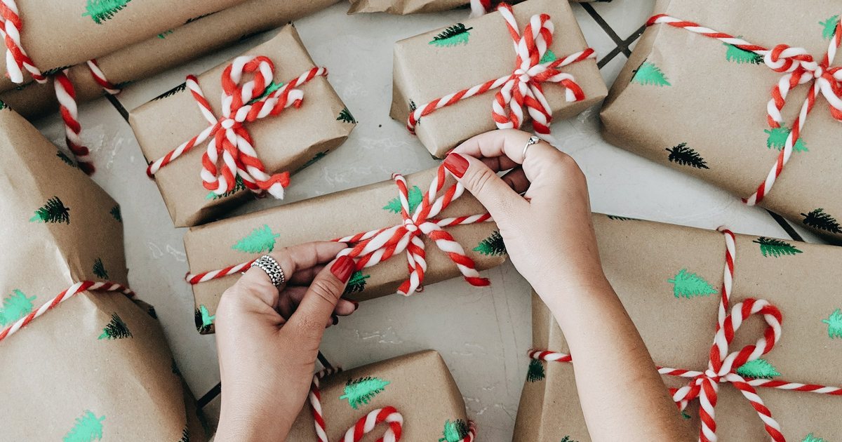 Hands wrapping a pile of small gifts